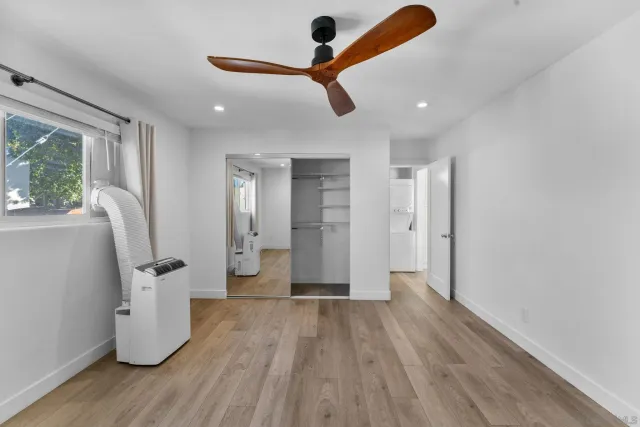 a view of a room with wooden floor and electronic appliances