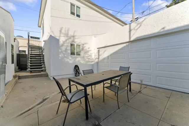 a backyard of a house with table and chairs