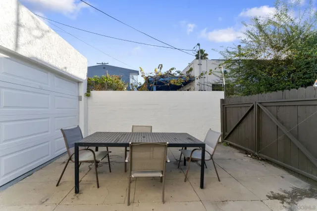 a view of patio with table and chairs and potted plants
