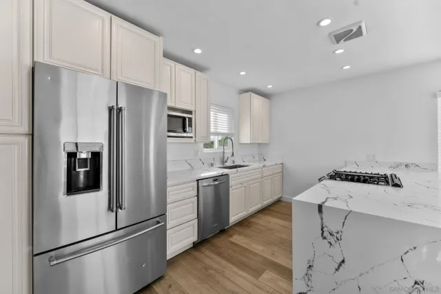 a kitchen with stainless steel appliances a refrigerator sink and microwave