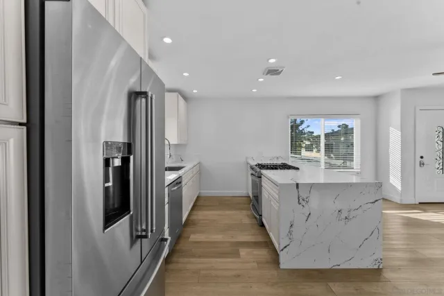a large kitchen with a large counter top and stainless steel appliances