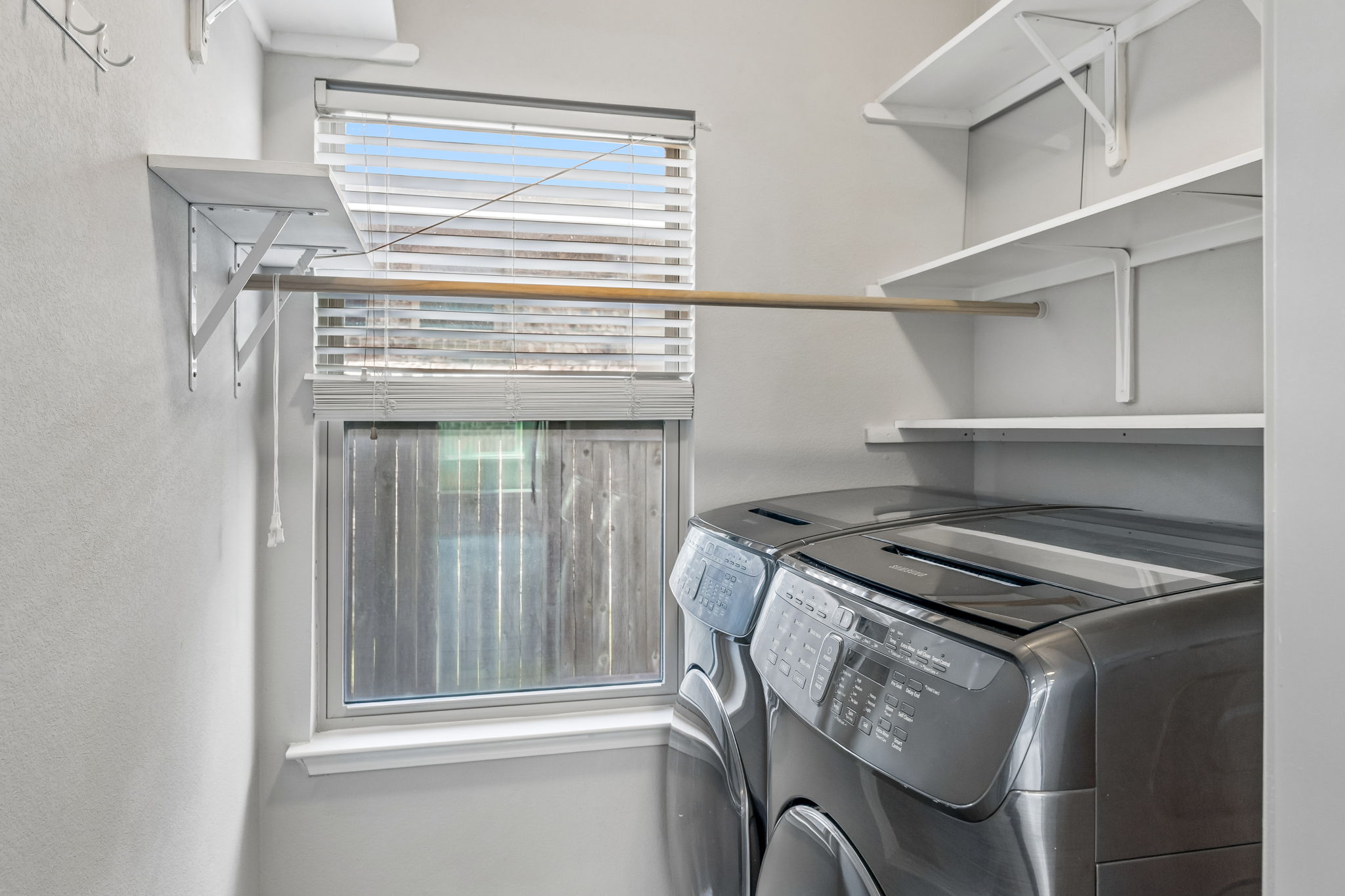 689 Nautical Loop Kyle, TX 78640 - Photo 28 of 34 A well-appointed laundry room features practical shelving and a convenient hanging rod.
