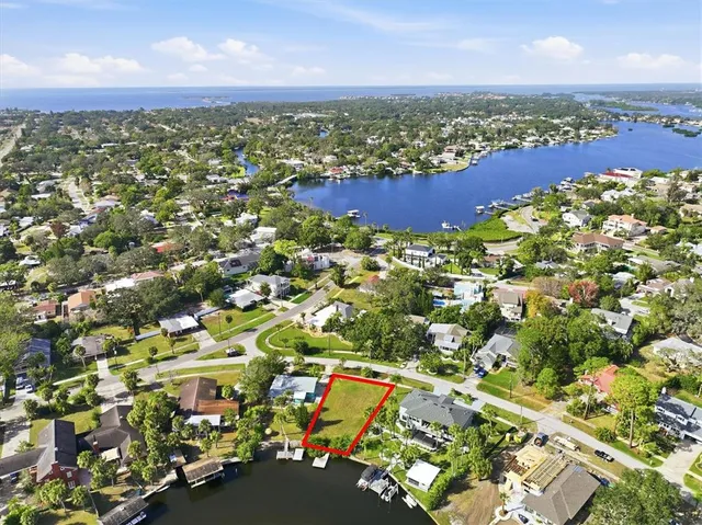 an aerial view of residential houses with outdoor space and trees