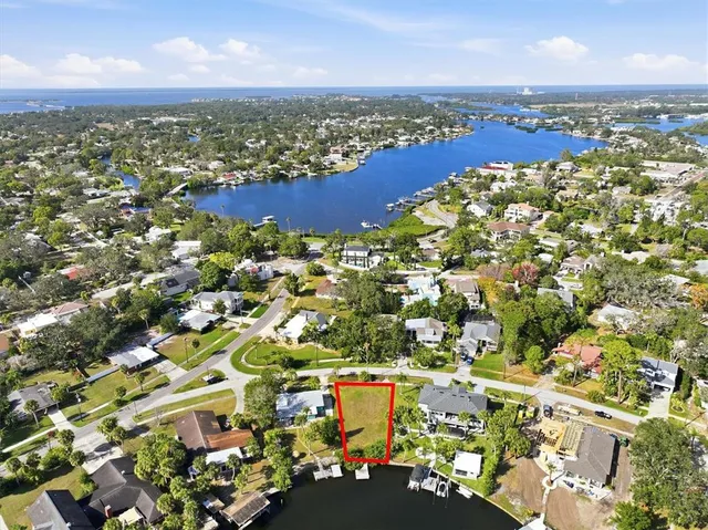 an aerial view of residential houses with outdoor space and lake view