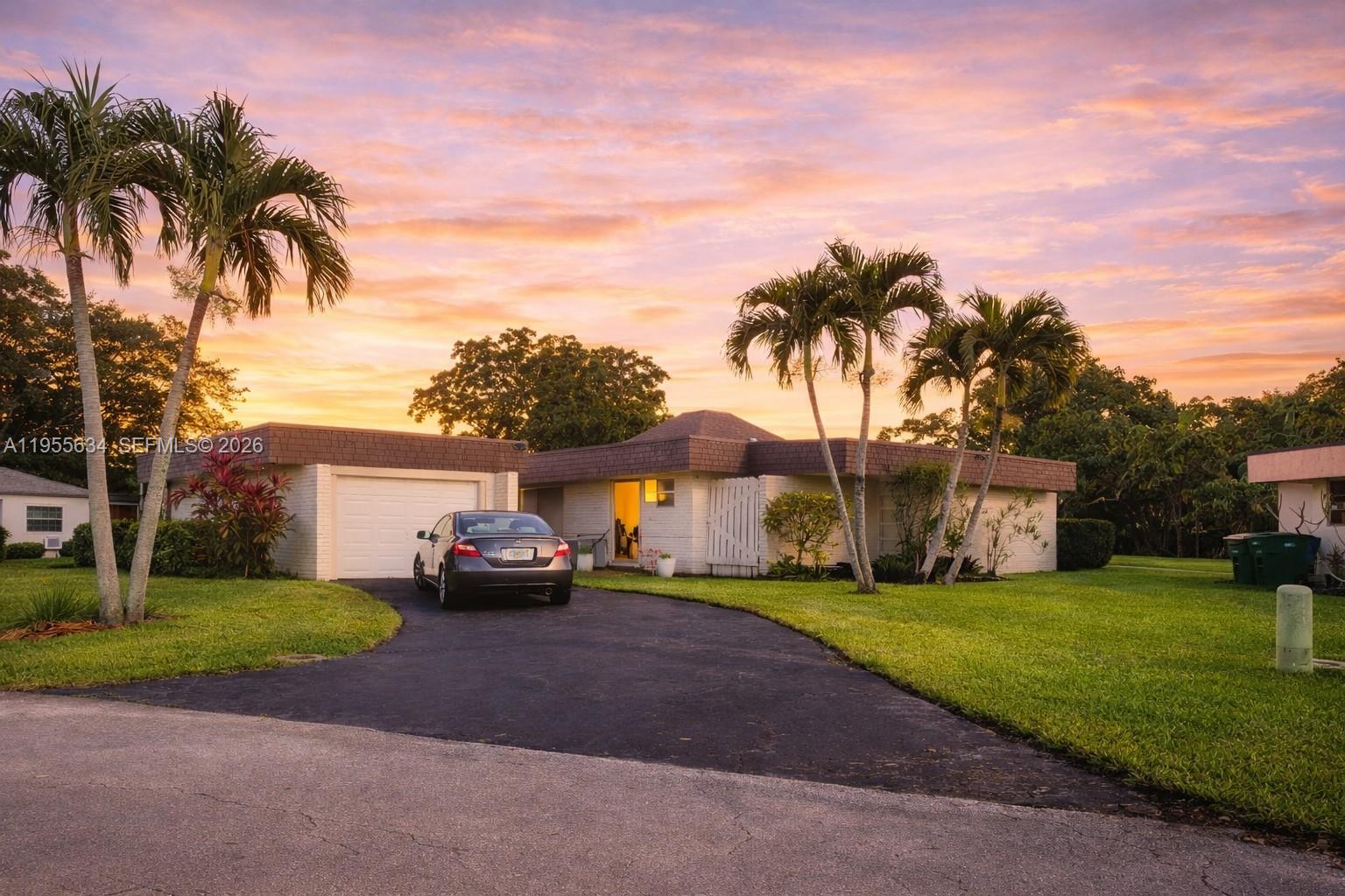 5700 White Hickory Circle Tamarac, FL 33319 - Photo 13 of 18 a front view of a house with a garden and yard