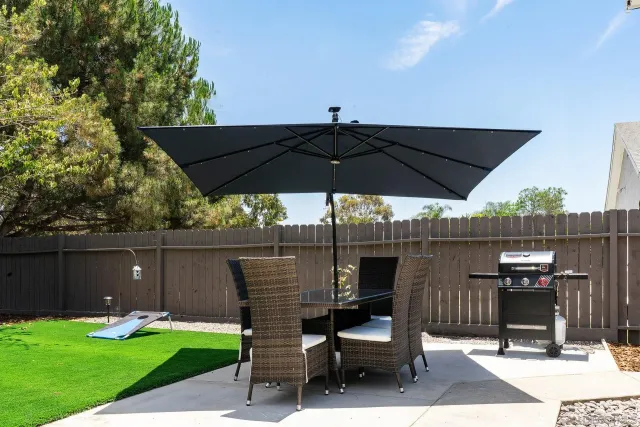 a view of a patio with table and chairs under an umbrella
