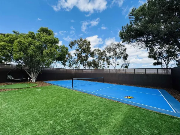 a view of a backyard with a house and wooden fence