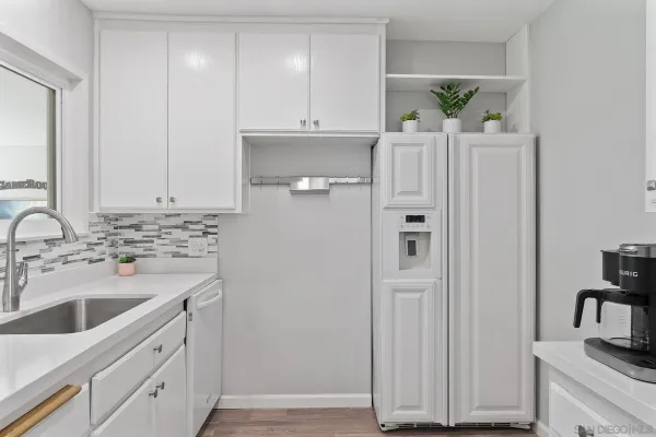 a kitchen with stainless steel appliances white cabinets and a sink