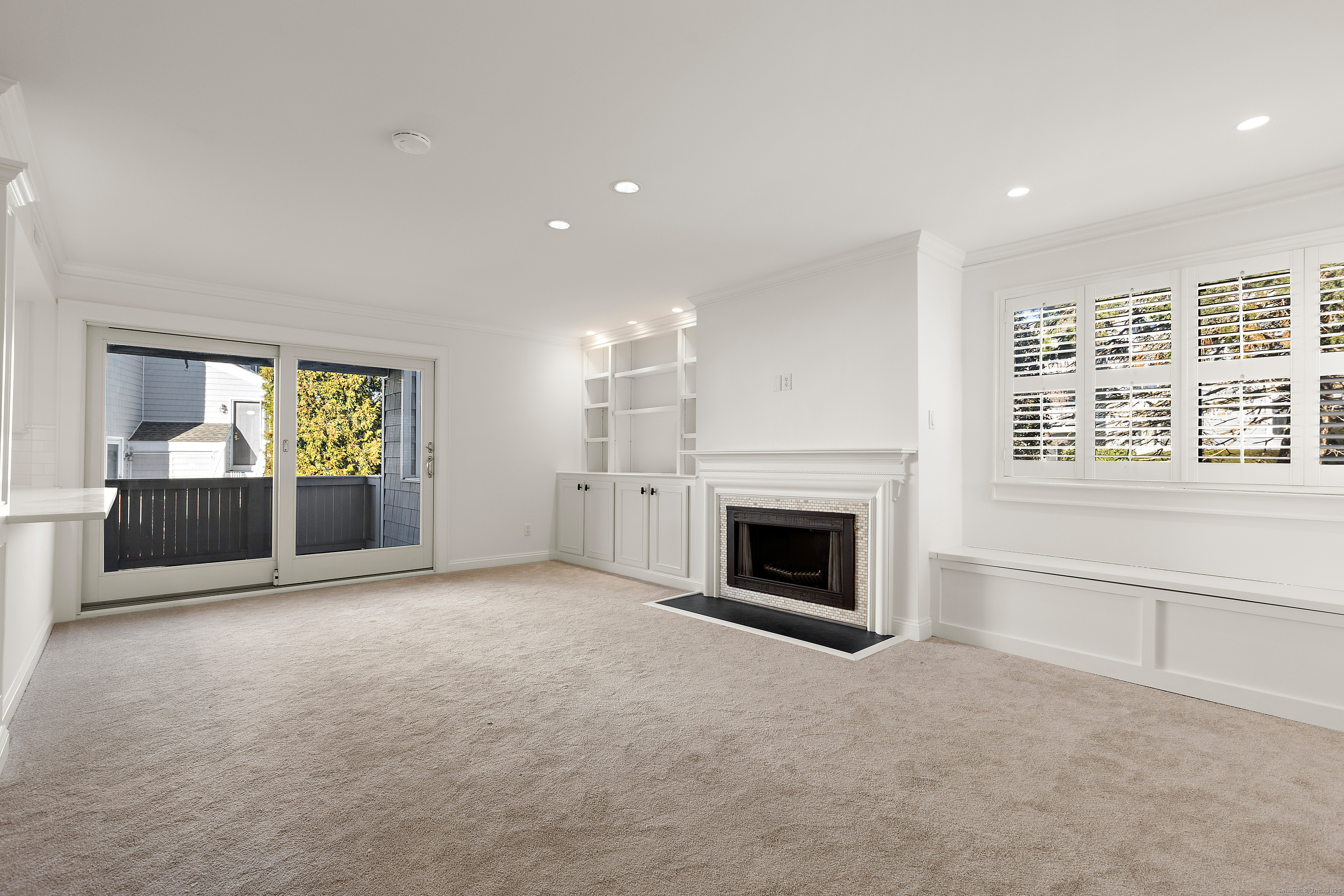 133 Rowayton Woods Drive, Unit 133 Norwalk, CT 06854 - Photo 8 of 40 Living Room features built-ins, fireplace and sliders to deck