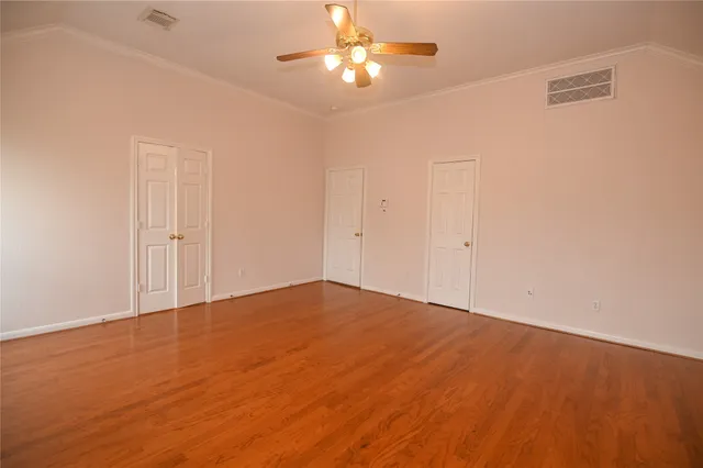 an empty room with closet and a chandelier fan