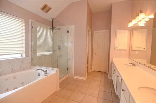 a spacious bathroom with a tub sink shower and mirror