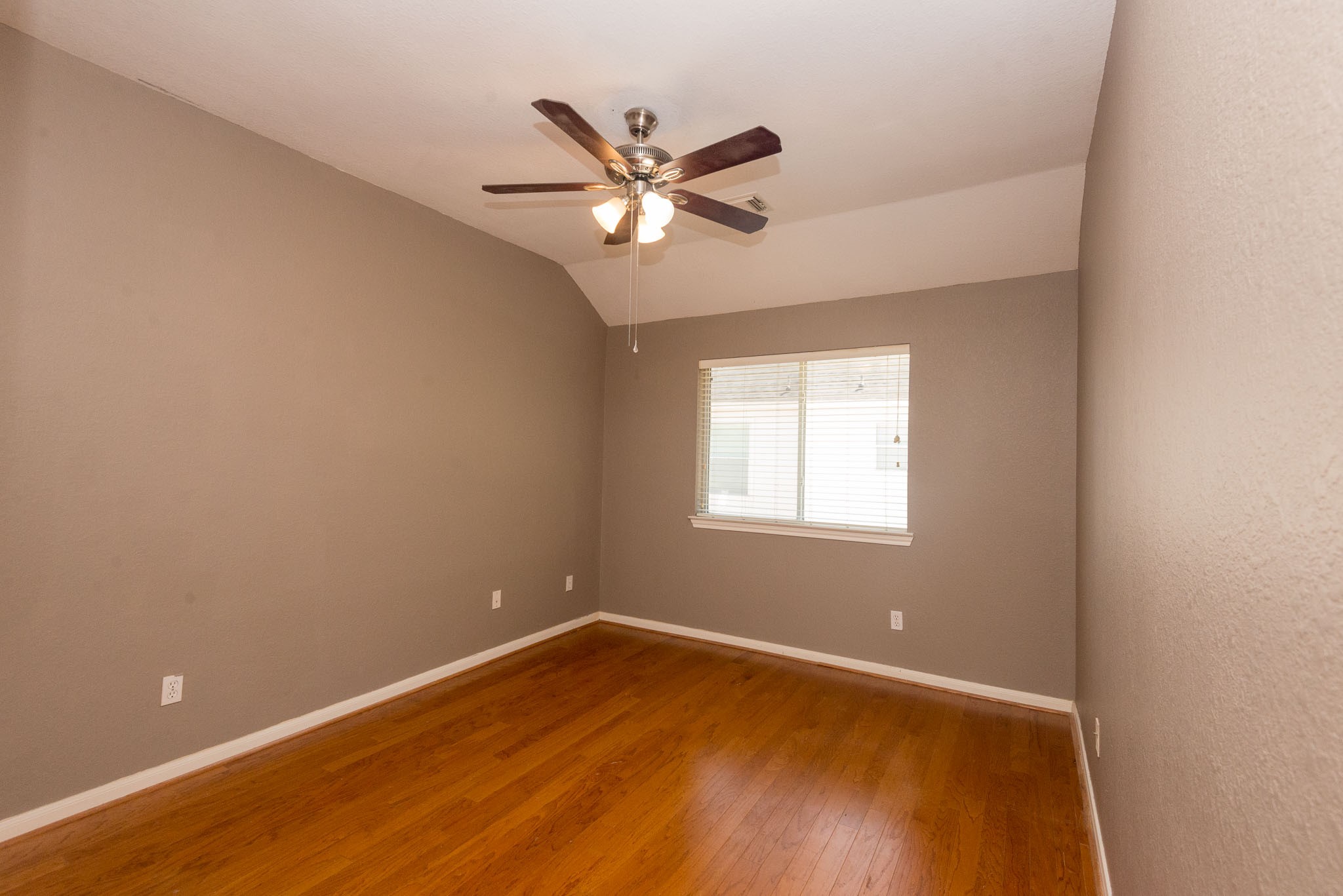 3023 Hidden Mist Court Pearland, TX 77584 - Photo 22 of 24 a view of a room with wooden floor and a ceiling fan