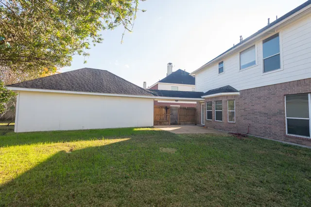 a view of a house with a yard and a large tree