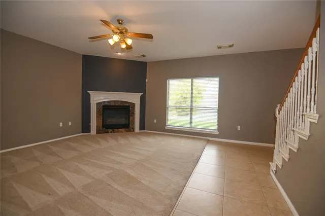a view of an empty room with a fireplace and a window