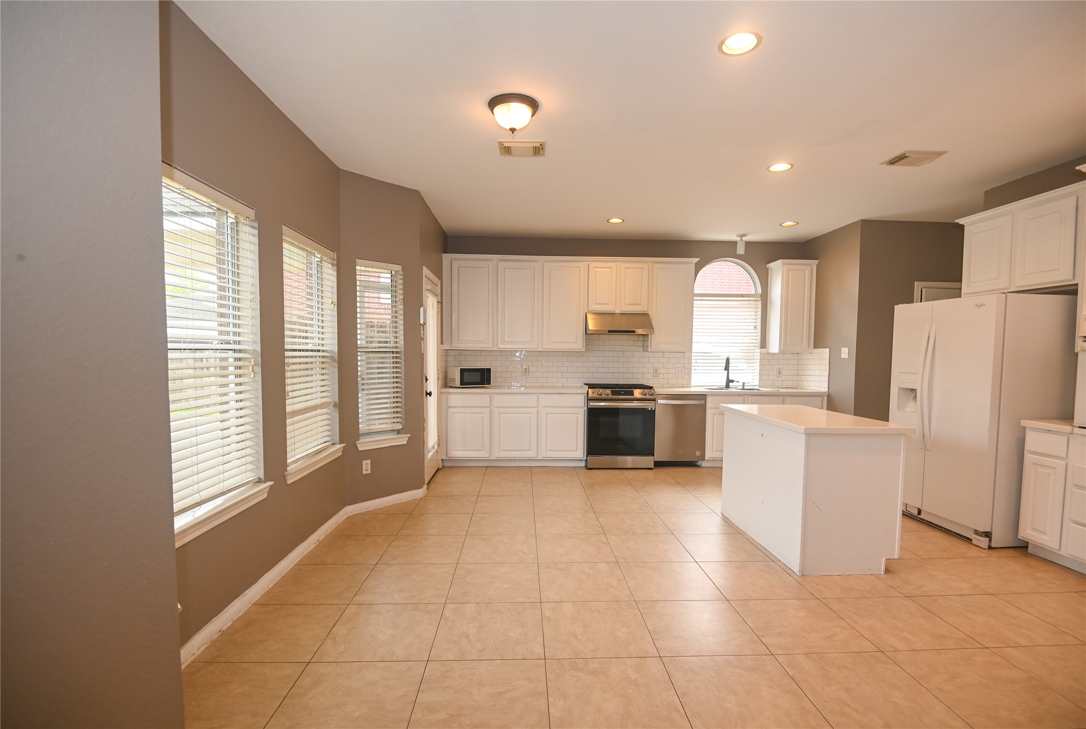 3023 Hidden Mist Court Pearland, TX 77584 - Photo 10 of 24 a large kitchen with white cabinets and white appliances