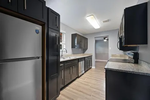 a large kitchen with a refrigerator and a sink