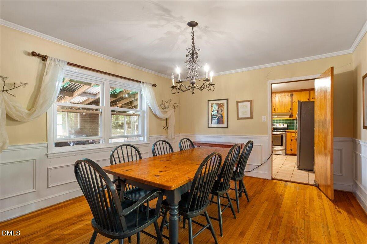 3107 Dixon Road Durham, NC 27707 - Photo 11 of 35 a dining room with furniture a chandelier and wooden floor