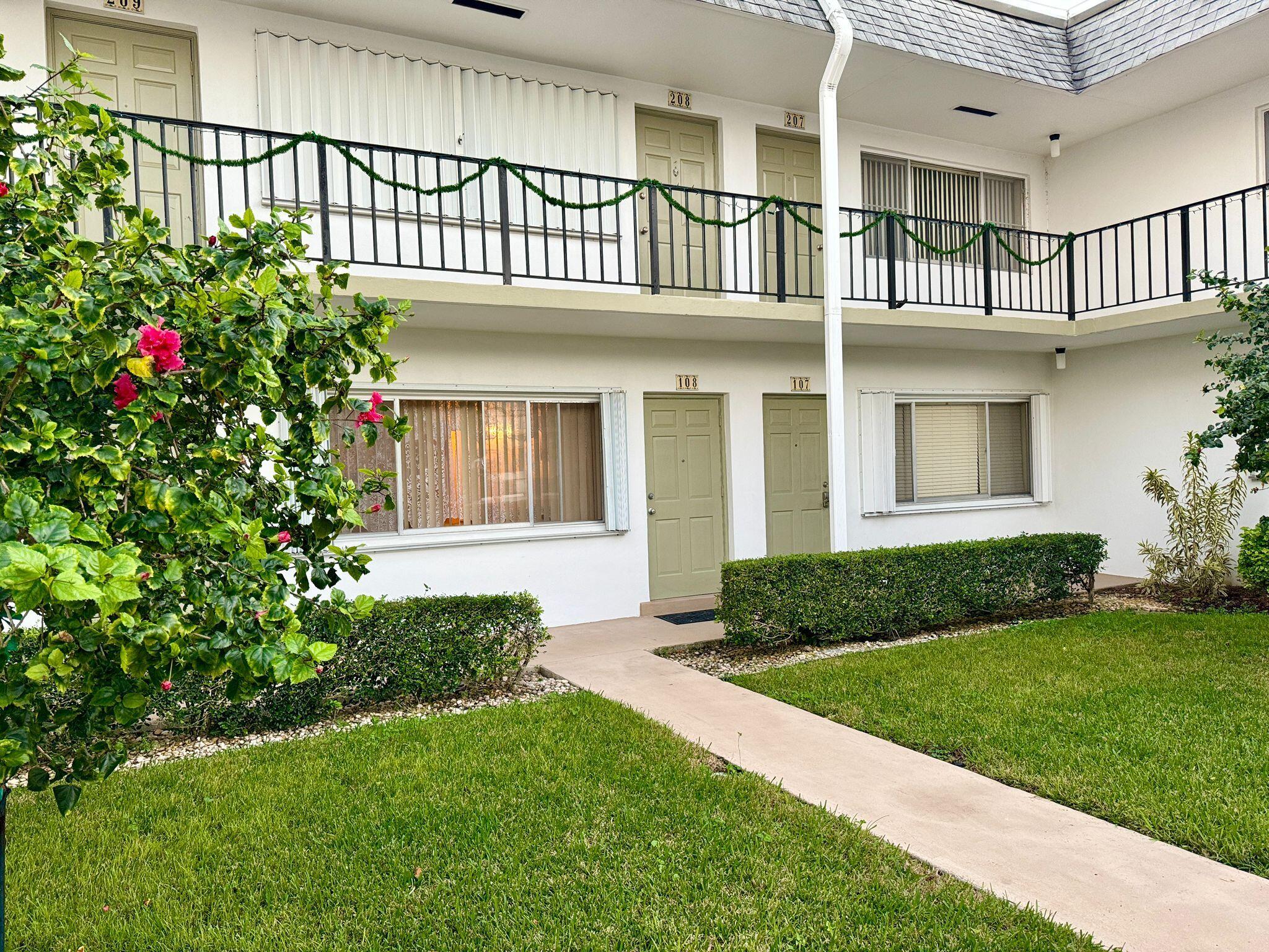 3040 Lake Osborne Drive, Unit 108 Lake Worth Beach, FL 33461 - Photo 1 of 27 a house view with a garden space