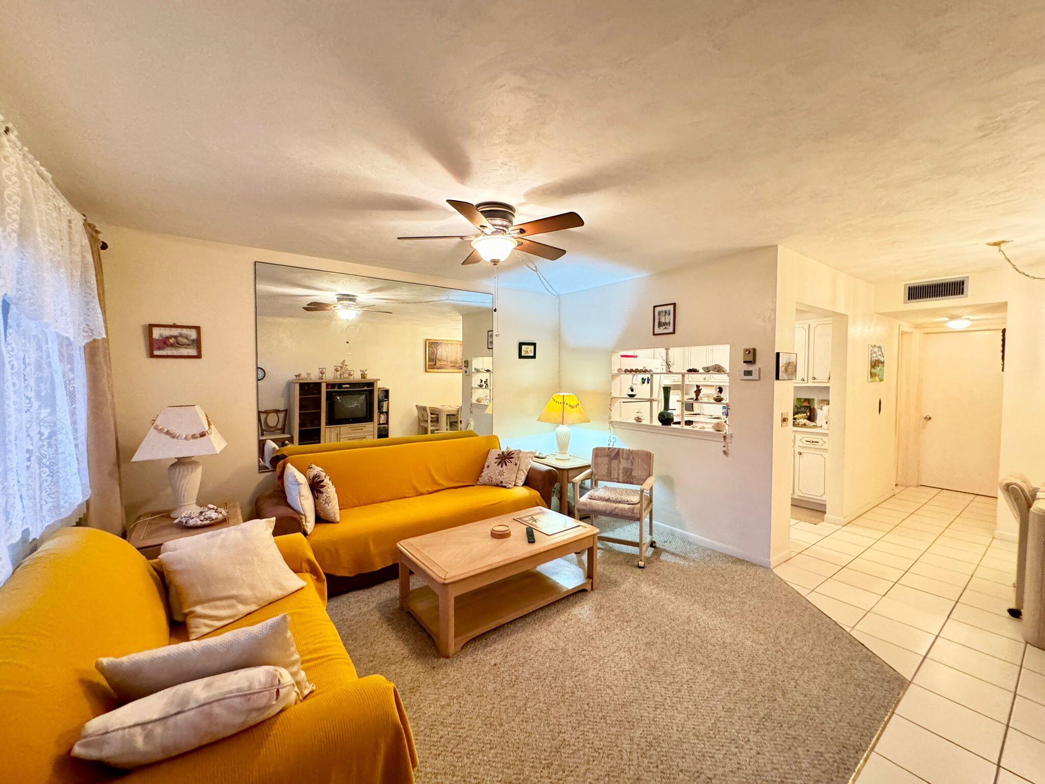 3040 Lake Osborne Drive, Unit 108 Lake Worth Beach, FL 33461 - Photo 4 of 27 a living room with furniture and a chandelier
