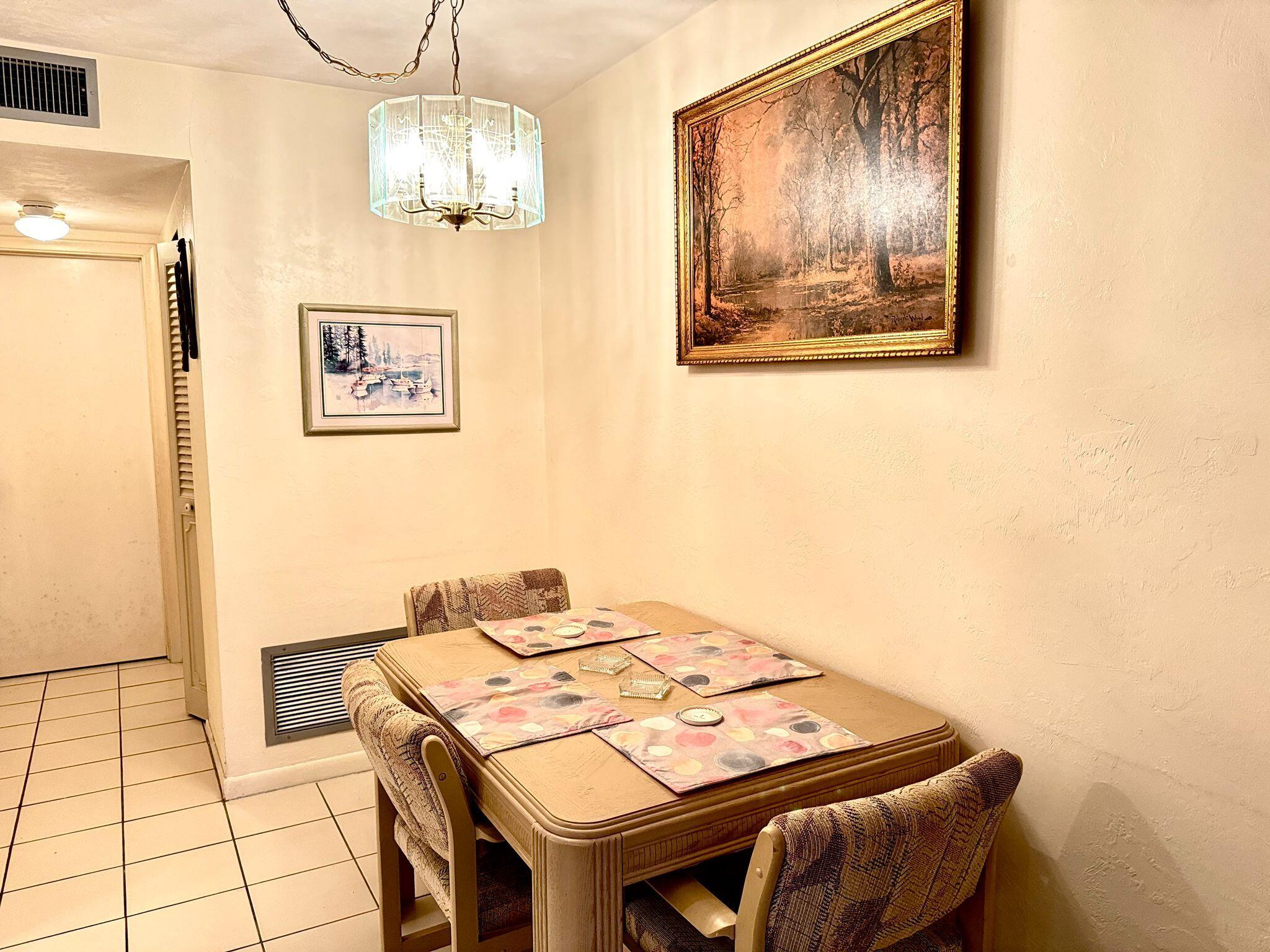 3040 Lake Osborne Drive, Unit 108 Lake Worth Beach, FL 33461 - Photo 6 of 27 a view of a dining area with furniture and chandelier