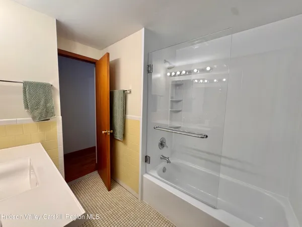 a bathroom with a tub shower and sink