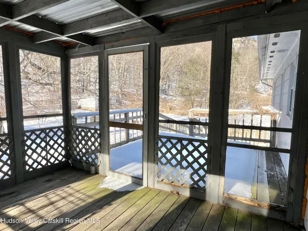a bedroom with furniture large window and wooden floor