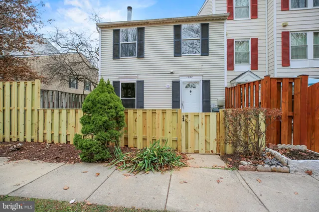 a view of a house with a small yard and wooden fence