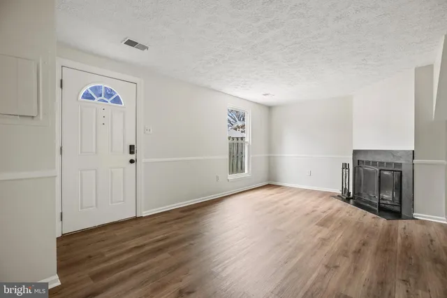 an empty room with wooden floor and fireplace