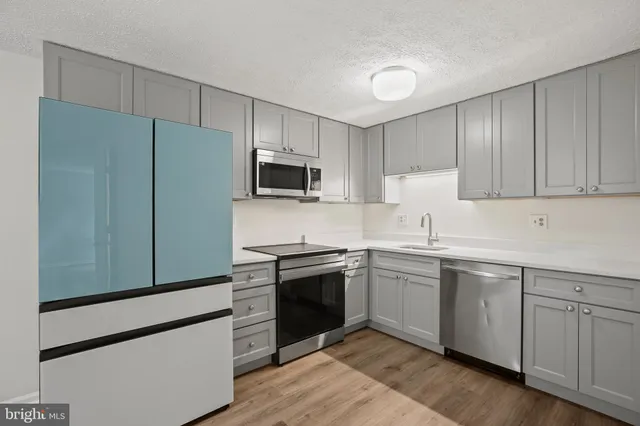 a kitchen with cabinets stainless steel appliances and sink