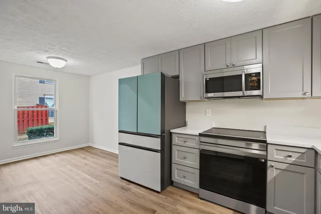 a kitchen with stainless steel appliances white cabinets and a stove top oven