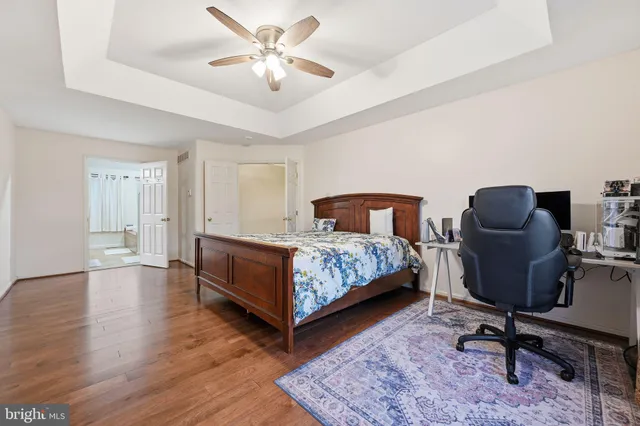 a bedroom with a bed a chair and a chandelier
