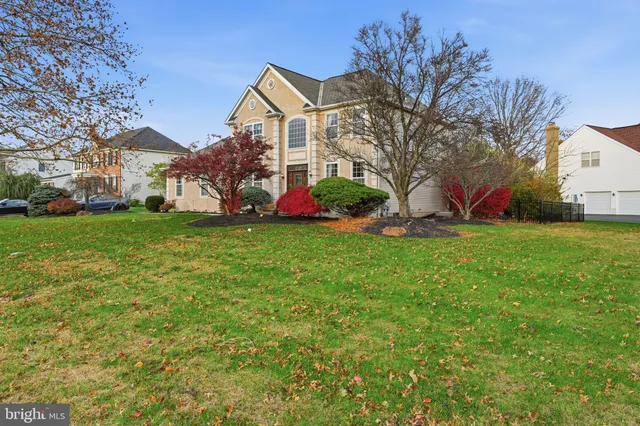 a view of a house with a big yard and large trees