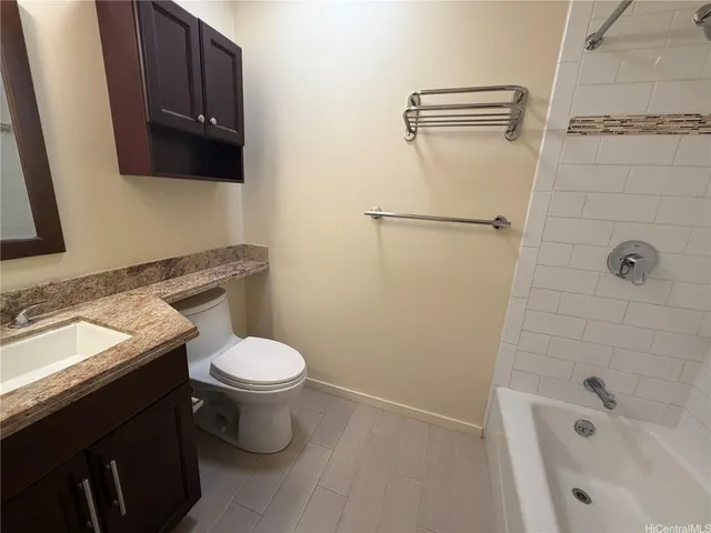 a bathroom with a granite countertop toilet sink and mirror