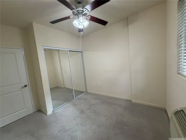 an empty room with chandelier fan