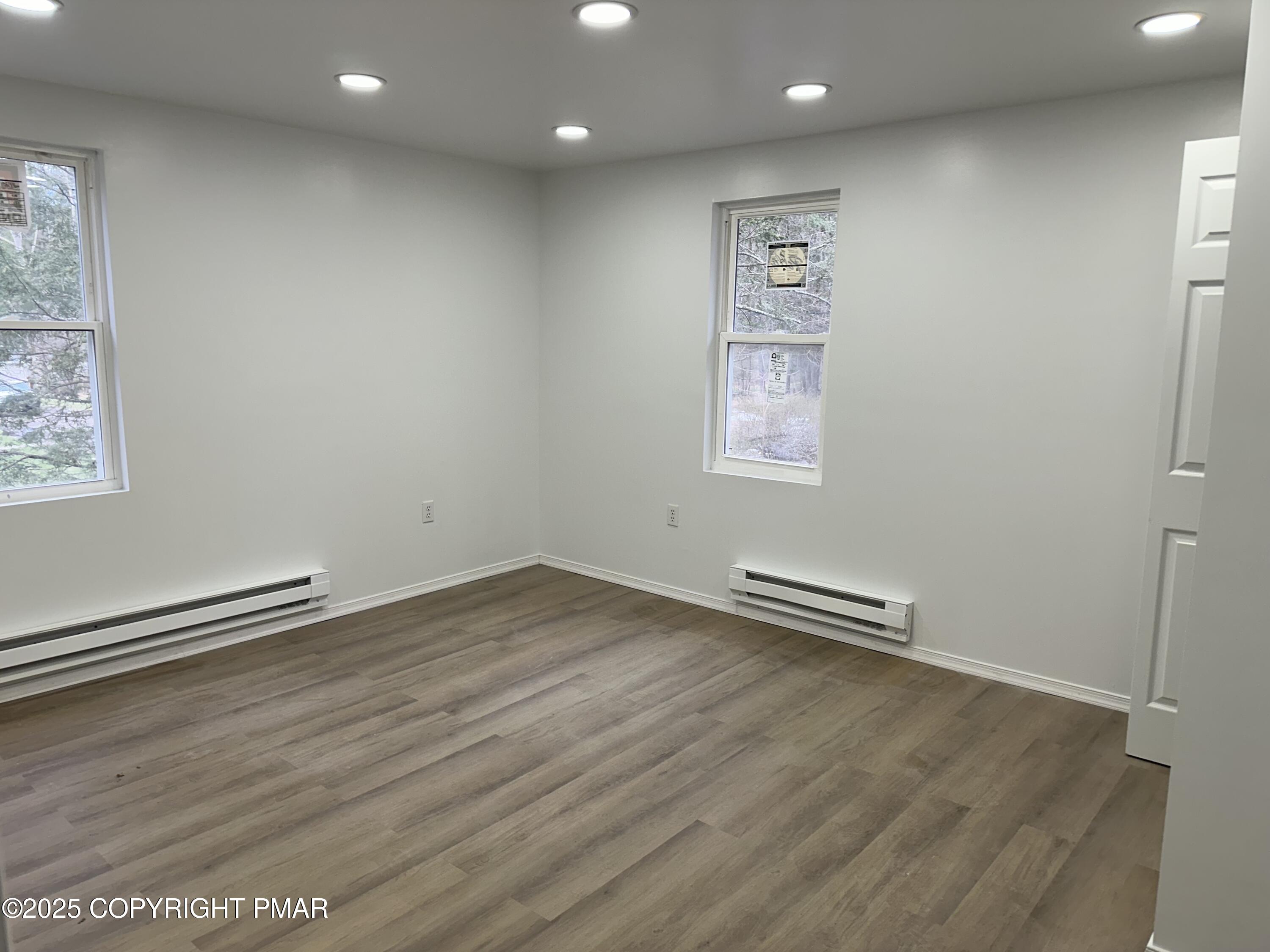 105 Glenmere Road Canadensis, PA 18325 - Photo 13 of 28 an empty room with wooden floor and windows