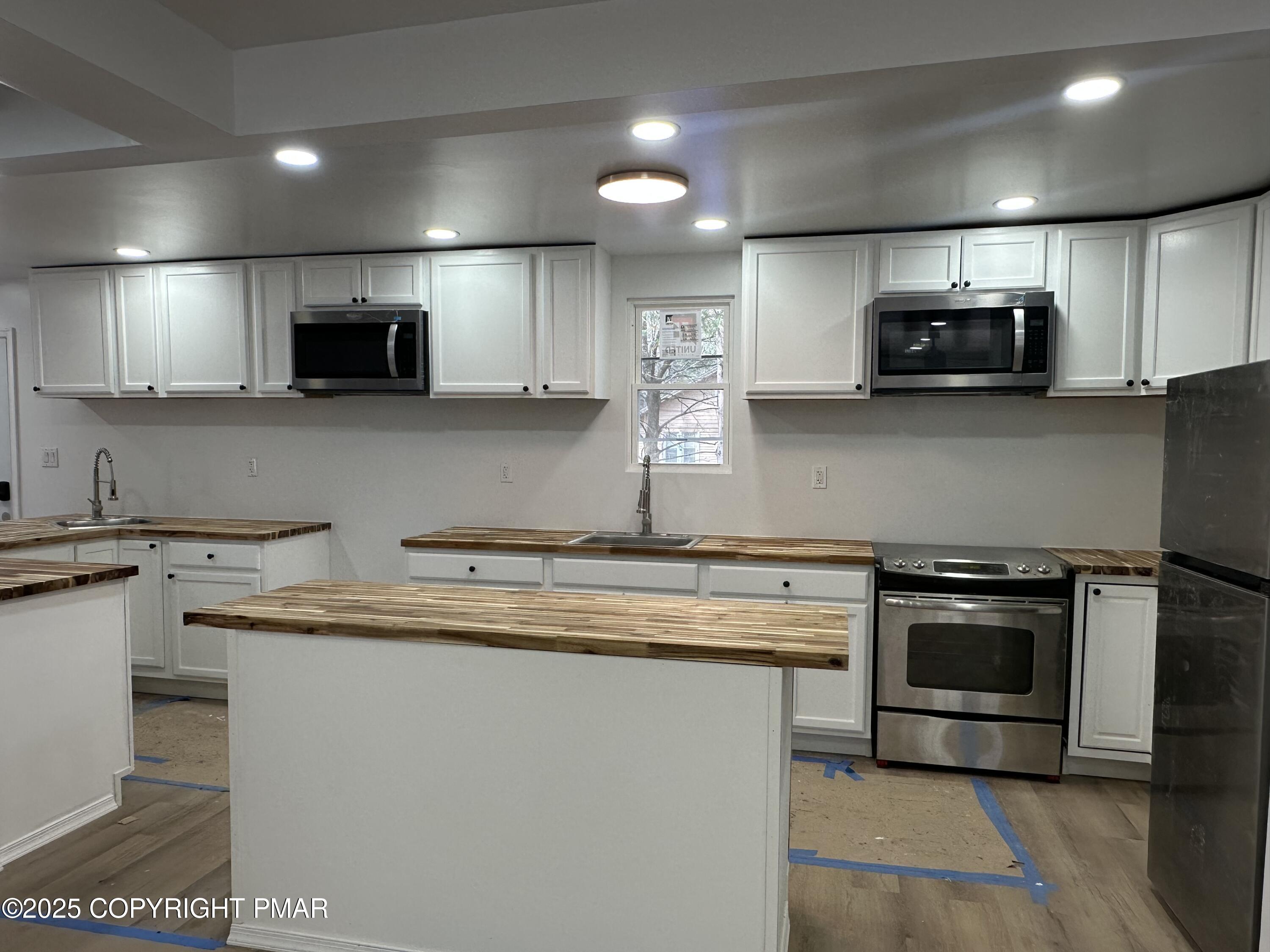 105 Glenmere Road Canadensis, PA 18325 - Photo 7 of 28 a kitchen with stainless steel appliances granite countertop a sink a stove a microwave and cabinets