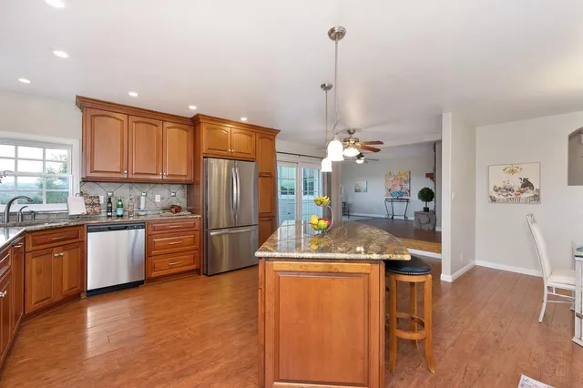 a kitchen with stainless steel appliances granite countertop a sink stove and cabinets