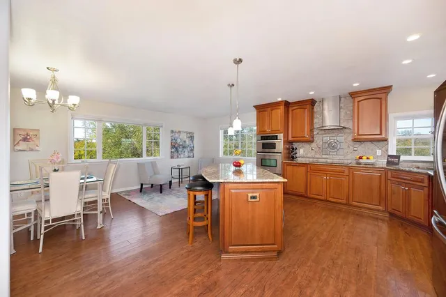 a kitchen with kitchen island a counter top a stove and a wooden floor