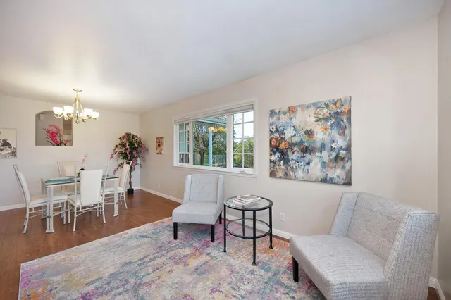 a view of a dining room with furniture a chandelier and wooden floor