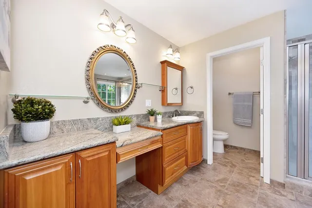 a bathroom with a granite countertop sink and a mirror