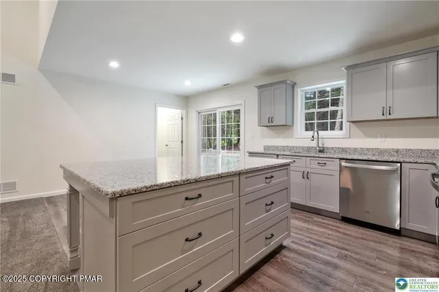 a kitchen with granite countertop white cabinets and white appliances