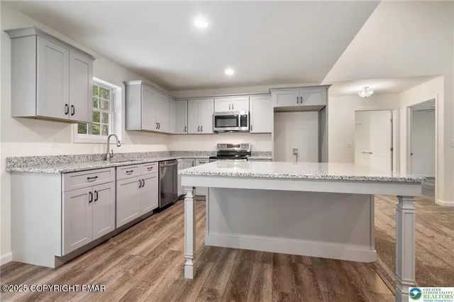 a kitchen with stainless steel appliances granite countertop a sink and cabinets