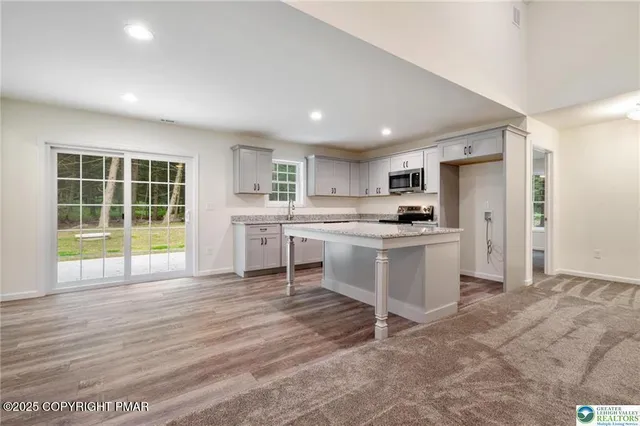 a kitchen with white cabinets and window