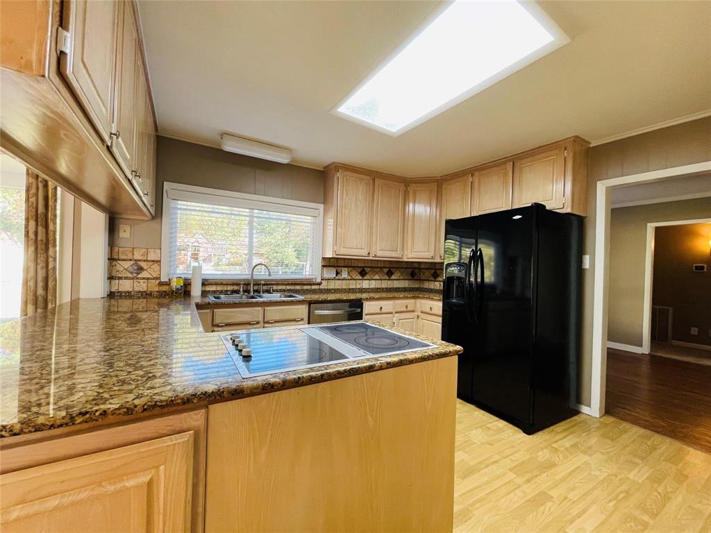 5000 Barbara Road River Oaks, TX 76114 - Photo 5 of 11 a kitchen with stainless steel appliances granite countertop a refrigerator a stove and a sink with wooden cabinets