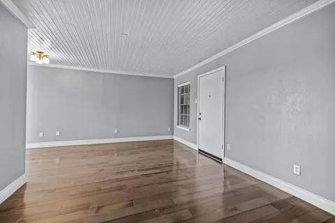 a view of an empty room with wooden floor