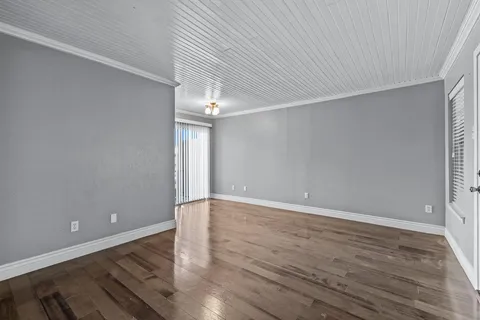 a view of an empty room with wooden floor