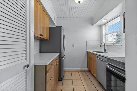 a kitchen with a sink a stove and cabinets