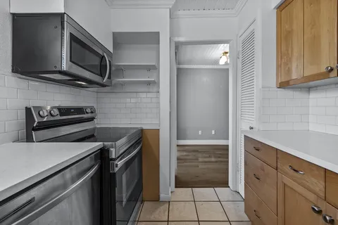 a kitchen with stainless steel appliances granite countertop a stove and a microwave