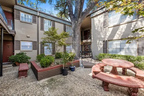a view of a patio with couches table and chairs potted plants and large tree