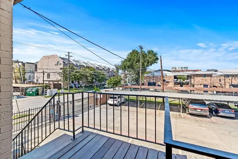 a view of a balcony with wooden floor and fence